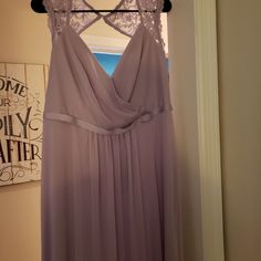 a dress hanging on a hanger in front of a door