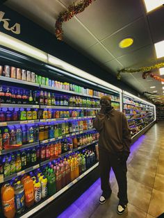 a man standing in front of a display case filled with drinks