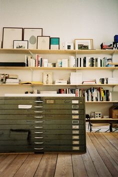 a room filled with lots of books on top of a wooden floor next to a book shelf