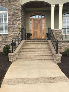 a house with steps leading up to the front door and entry way that is made out of stone