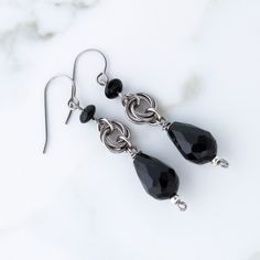 Want to add a touch of elegance with a historical vibe? These black teardrop dangle earrings with titanium chainmail filigree are your new go-to. With intricate twisted chainmail rosettes and black teardrop beads, they bring timeless charm to any look. All metal components are made with grade 1 titanium, so they're hypoallergenic and nickel-free - ideal for sensitive ears. Perfect for fans of dark academia, Victorian, gothic, goth, whimsigoth, ren faire, and Celtic jewelry styles. The silver-ton Victorian Goth Aesthetic, Dark Academia Jewelry, Black Statement Earrings, Titanium Earrings, Nickel Free Earrings, Teardrop Dangle Earrings, Free Earrings, Teardrop Beads, Celtic Jewelry