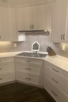 a kitchen with white cabinets and wooden floors