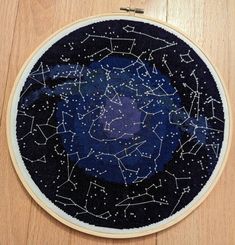 a cross - stitch pattern with stars in the sky on a wooden surface, as seen from above