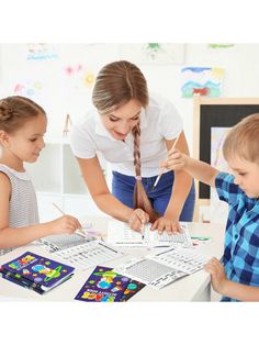 a woman and two children at a table working on their workbook pages with pencils