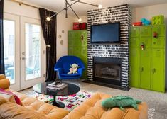 a living room filled with furniture and a flat screen tv mounted on the wall above a fire place