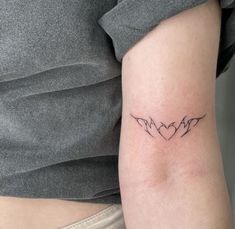 a woman's arm with two birds in the shape of heart tattoos on it