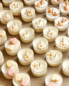 many small candles are arranged in rows on the floor, with tiny hearts and flowers