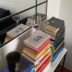 a stack of books and wine glasses on a table