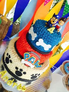 there is a birthday cake with mickey mouse on top and paw patrol on the bottom