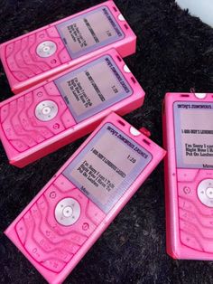 three pink mp3 players sitting on top of a black rug