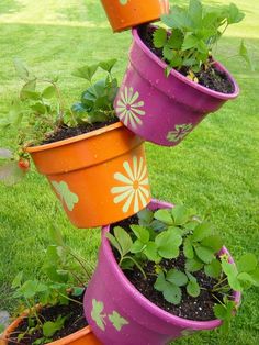 three flower pots are stacked on top of each other with plants growing out of them