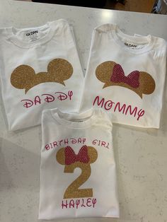 three t - shirts with mickey mouse ears and the number two on them, both for mom and daughter