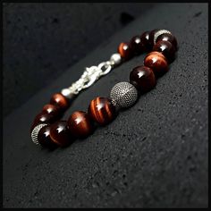 This handmade high grade red tiger's eye beaded bracelet will perfectly fit with your style. It is a perfect gift for you and all your loved one for all special days such as birthday, valentine's day, father's day, anniversary etc. We used durable steel line and 925 sterlind silver accessorize on this special design. Please kindly check your wrist size according to the picture of measurement instruction and order the same size.  All our designs prepare by hand according to the your given sizes with love. We offer 8 size option between 5.9-8.7 inches (15-22 cm) , please DM us to demand different wrist size. Used materials; 8 mm red tiger's eye  8 mm 925 sterling silver ancient style balls 925 sterling silver closure materials Steel line ☆ABOUT US☆ https://www.etsy.com/shop/SevenArtJewelry?r Masculine Jewelry, Smoky Quartz Pendant, Black Beaded Bracelets, Red Tigers Eye, Tiger Eye Bracelet, Tiger Eye Beads, Mens Beaded Bracelets, Eye Bracelet, Fall Jewelry