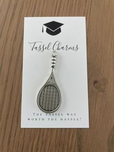 a badge with a tennis racket on it sitting on top of a wooden table