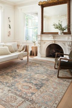 a living room filled with furniture and a fire place in front of a mirror on the wall