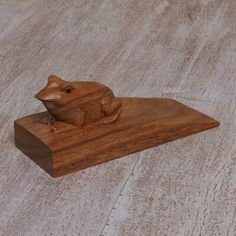 a wooden mouse sitting on top of a piece of wood