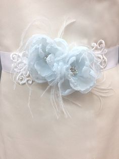 This is a majestic vintage-inspired sash beautifully adding incredibly chic for your special occasion outlook This piece has a lot of movement, and it is incredibly ethereal looking. The feathers gently sway as you walk- Just breathtaking! Handmade Baby Blue chiffon ruffles rose flower bridal sash belt , accent with Venice white lace. This beautiful flowers beaded with rhinestones, crystals and pearls and softened with ostrich feather The applique has been attached to a White double face satin r Elegant Bridal Belt With Handmade Flowers For Weddings, White Embellished Lace Bridal Belt, Blue Flower Belt, Elegant Bridal Belt With Handmade Flowers, Light Blue Flower-shaped Beaded Jewelry, Blush Shoes, Ivory Wedding Gown, Flower Belt, Chiffon Shawl