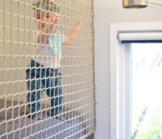 a little boy standing in front of a window