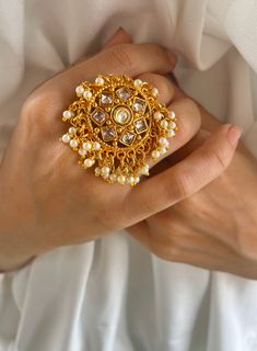 Experience Royal Grandeur with Our Golden Beaded Rajwadi Rings Collection! Transport yourself to the majestic courts of ancient India with our mesmerizing Rajwadi rings, crafted to exude opulence and splendor fit for royalty. Each ring is a testament to the rich heritage of Rajwadi artistry, meticulously handcrafted with precision and adorned with intricate golden beads. Inspired by the regal adornments of Indian nobility, our Rajwadi rings feature a stunning array of traditional motifs and orna White Stone Work Wedding Gift, White Stone Work Jewelry For Anniversary, Intricate Design Pearl Ring For Wedding, Gold Handmade Rings For Marriage, Fusion Style Gold Wedding Rings, Gold Fusion Style Wedding Rings, Fusion Style Wedding Ring With Intricate Design, Gold Fusion Wedding Rings, Gold Crystal Toe Ring For Wedding