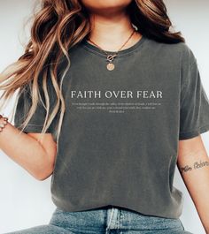 This tshirt will be your new favorite! Wearing this bible verse as a reminder to yourself to have faith over fear and to remind those around you!  PLEASE REFER TO SIZE CHART BEFORE ORDERING Size up for an oversized fit. Model is wearing M. ❤ Q U I C K   F A C T S * - 100% ringspun cotton  - Machine wash cold, dry on low heat for best results  ❤ S I Z I N G * - Sizing is unisex so fits loose but not overly large. Size up for an oversized fit - Size guide and fit:  SMALL: width 18in, length 26in MEDIUM: width 20in, length 28in LARGE: width 22n, length 29in XL: width 24in, length 30in 2XL: width 26in, length 31in 3XL: width 27in, length 32in ❤ S H I P P I N G * T I M E S * - Our items are individually made with love for each of our buyers. Because of this, our processing time is 2-5 business Bible Verse Encouragement, Faith Based Tshirt Designs, Verse Encouragement, Christian Statement Shirt, Faith Based Shirt, Jesus Shirts Christian Clothing Elevated Faith, Christian Streetwear, Christian Merch, Cotton T-shirt With Faith Text Print