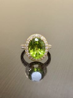 DeKara Designs Collection Our latest design! An elegant and lustrous Peridot Halo Diamond Engagement Ring. Metal- 18K Yellow Gold, .750. Stones- Oval Natural Peridot 11.6 MM x 9.4 MM 4.16 Carats, 44 Round Diamonds F-G Color VS1-VS2 Clarity 0.46 Carats. Latest of my creations! A Beautiful Peridot Diamond Halo Engagement Ring Made in 18K Yellow Gold. There is a beautiful genuine green peridot in the center of the ring that is professionally set in between four double prongs. The peridot is a beaut Luxury Yellow Gold Peridot Rings, Formal Peridot Diamond Ring In Yellow Gold, Luxury Peridot Rings With Accent Stones, Luxury Tsavorite Ring With Gemstone Accents, Oval Tsavorite Diamond Ring For Formal Occasions, Yellow Gold Peridot Rings With Gemstone Accents, Luxury Peridot Ring For Formal Occasions, Luxury Tsavorite Rings With Halo Setting, Oval Tsavorite Ring With Gemstone Accents