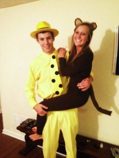 a man and woman dressed in costumes posing for a photo together with the cat on the hat