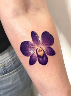 a woman's arm with a purple flower tattoo on it