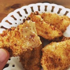 someone is holding up some fried food on a plate