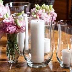 a table topped with vases filled with flowers and candles