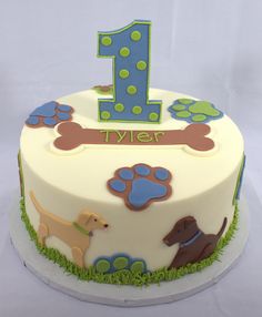 a birthday cake for a one year old boy with dogs and paw prints on it