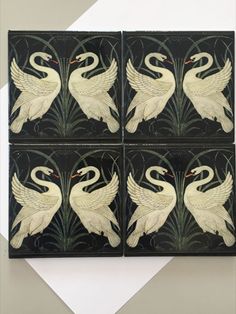 four black and white tiles with swans on them