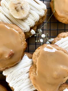 some cookies with icing and bananas on top are sitting on a wire cooling rack