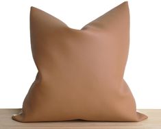 a brown pillow sitting on top of a wooden table