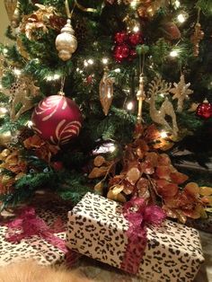 a dog laying under a christmas tree with presents on the floor next to it and an ornament