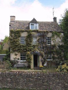 an old stone house with ivy growing on it