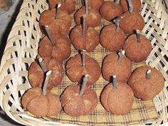 there are many small brown apples in the basket on the table and one is cut open