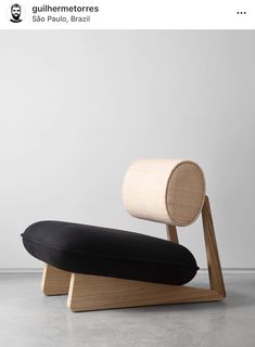 a black and white pillow sitting on top of a wooden stand next to a wall