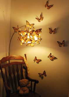 a teddy bear sitting in a chair next to a lamp and butterflies on the wall