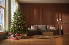 a living room with a christmas tree in the corner and presents on the floor next to it