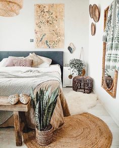 a bed sitting in a bedroom next to a table with a potted plant on it