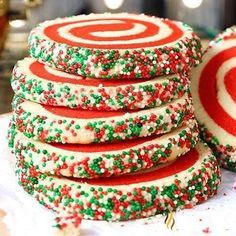 a stack of decorated cookies sitting on top of a white plate next to a red and green peppermint