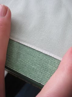 a person with their foot on the edge of a bed next to a sheet and pillow