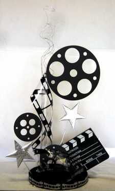 a black and white film reel with silver stars on the top, next to a movie clapper