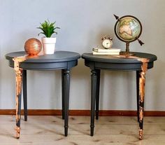 two black tables sitting next to each other on top of a hard wood floored floor