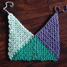 a crocheted triangle is sitting on the floor