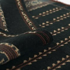 a black and brown blanket laying on top of a white table