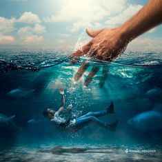 two people swimming in the ocean with their hands reaching out to touch each other's hand