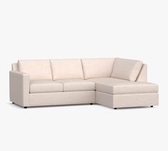 a white sectional couch sitting on top of a white floor