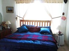 a bed with blue sheets and pillows in a bedroom