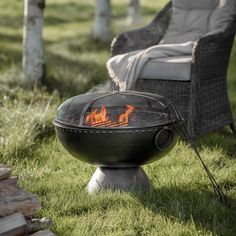 an outdoor fire pit sitting in the grass